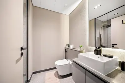 a white bathroom with a sink and a toilet at Bright Studio in MAG Eye in Dubai