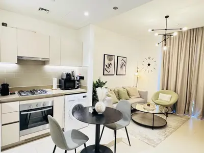 a kitchen and living room with a couch and a table at Creek Views 1 BR, Mins to Downtown in Sobha Creek Vistas in Dubai