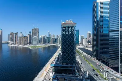 a view of a city with a tower next to the water at Spacious Studio in Damac Maison Prive Canal Views in Dubai