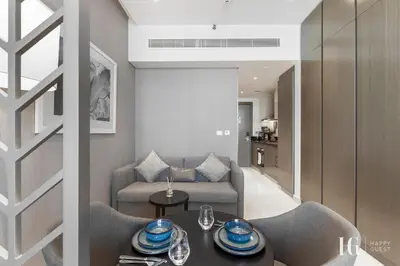 a living room with a table and a couch at Spacious Studio in Damac Maison Prive Canal Views in Dubai