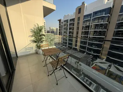 a balcony with a table and chairs on a building at Cozy 01 BHK with Balcony in Dubai