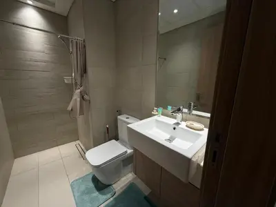 a bathroom with a sink and a toilet and a mirror at Cozy 01 BHK with Balcony in Dubai