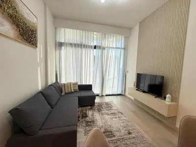a living room with a couch and a flat screen tv at Cozy 01 BHK with Balcony in Dubai