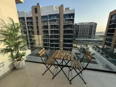 a balcony with a table and chairs on a building at Cozy 01 BHK with Balcony in Dubai