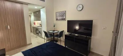 a bedroom with a bed and a television and a table at Studio Uni at Azizi Riviera 43 Near Business Bay in Dubai