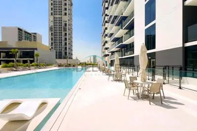 a swimming pool with chairs and tables on a building at Delightful 1BR in Binghatti Corner, Jumeirah Village Circle by Deluxe Holiday Homes in Dubai