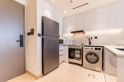 a kitchen with a refrigerator and a washer and dryer at Delightful 1BR in Binghatti Corner, Jumeirah Village Circle by Deluxe Holiday Homes in Dubai