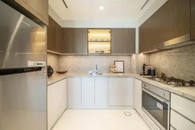 a kitchen with white cabinets and a sink at Grand Bleu 02 - LIMITED OFFER! 1BR Coastal Retreat at Emaar Beachfront in Dubai