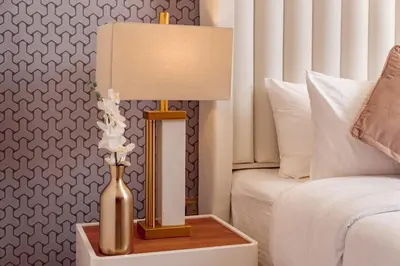 a lamp and a vase on a table next to a bed at Elite Royal Apartment - Full Burj Khalifa & Fountain View - Largest Layout - Half Floor - Luxurious - Archon in Dubai
