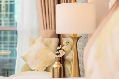 a lamp sitting next to a bed with flowers on it at Elite Royal Apartment - Full Burj Khalifa & Fountain View - Largest Layout - Half Floor - Luxurious - Archon in Dubai