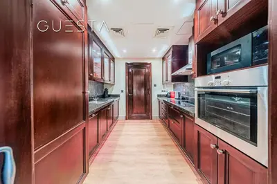 a large kitchen with wooden cabinets and appliances at Zaafaran 1 by Emaar, Downtown Dubai in Dubai
