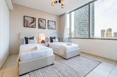 two beds in a room with a large window at Modern 2BR in Sky Gardens, DIFC by Deluxe Holiday Homes in Dubai
