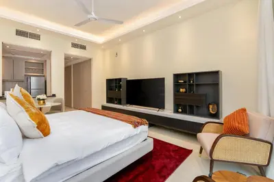 a bedroom with a bed and a flat screen tv at White Sage Incredible Studio Next to Metro in Dubai