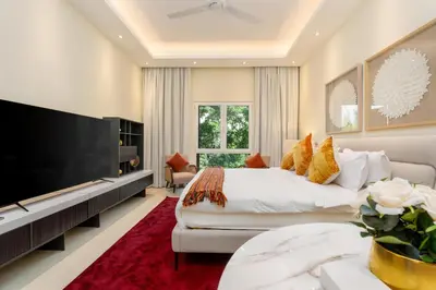 a bedroom with a large bed and a large television at White Sage Incredible Studio Next to Metro in Dubai