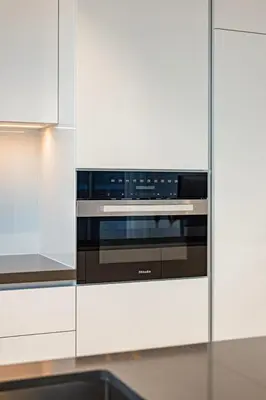 a kitchen with white cabinets and a stove at Luxury 2BR Prime Location & Burj Views in Dubai