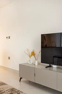 a living room with a flat screen tv on a cabinet at Luxury 2BR Prime Location & Burj Views in Dubai