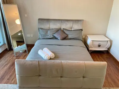a large bed with a large headboard in a bedroom at Executive Tower 1bhk Business Bay in Dubai