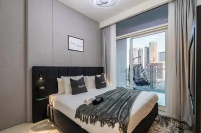 a bedroom with a large bed with a large window at Luxury 2BD Apt with Pool GYM & Burj Khalifa Views in Dubai