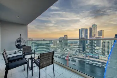 a balcony with chairs and a view of a city at Luxury 2BD Apt with Pool GYM & Burj Khalifa Views in Dubai