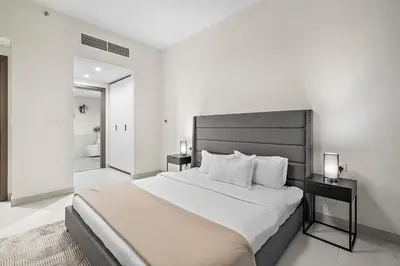 a bedroom with a large bed and a bathroom at FIRST CLASS 2BR Panoramic Views of Dubai Frame in Dubai