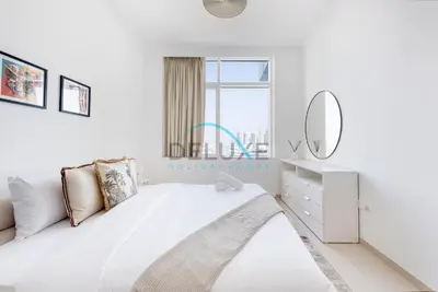 a white bedroom with a bed and a mirror at Spectacular 1BR in Botanica Tower 1 Dubai Marina by Deluxe Holidy Homes in Dubai