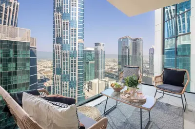 a balcony with chairs and a table and a view of a city at Frank Porter - Urban Oasis in Dubai