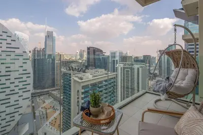 a balcony with a chair and a view of a city at Frank Porter - Urban Oasis in Dubai