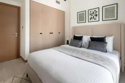 a bedroom with a large bed with white sheets at Frank Porter - Urban Oasis in Dubai