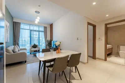 a kitchen and living room with a table and chairs at HAVN - 1 Bedroom in Azizi Park Avenue, Meydan in Dubai