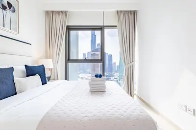 a bedroom with a large white bed with a large window at Premium 3BR l Office with Burj Khalifa & Fountain Views in Dubai