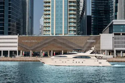 a white yacht in the water in front of buildings at FAM Living - Urban Oasis 2bedroom, Business Bay in Dubai
