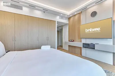 a hotel room with a bed and a flat screen tv at bnbme - Luxury 4BR Downtown Views II Apt Burj Khalifa Views Pool Gym Parking in Dubai