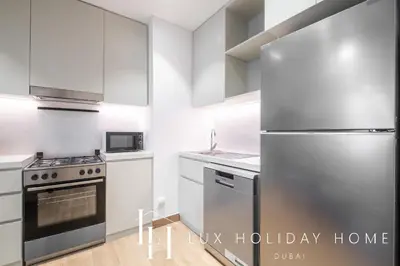 a kitchen with a stainless steel refrigerator at LUX The La Mer Infinity View- Luxury Boho Suite 2 in Dubai