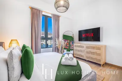 a bedroom with a bed and a tv at LUX The La Mer Infinity View- Luxury Boho Suite 2 in Dubai
