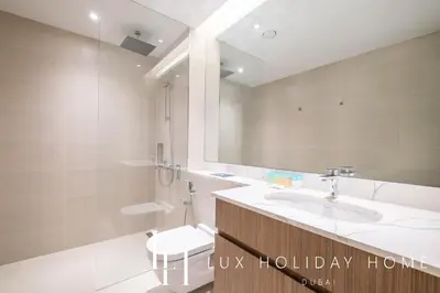 a bathroom with a sink and a toilet and a mirror at LUX The La Mer Infinity View- Luxury Boho Suite 2 in Dubai