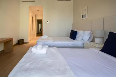 a hotel room with two beds with towels on them at HiGuests - Experience Coastal Elegance at La Rive 2 in La Mer in Dubai