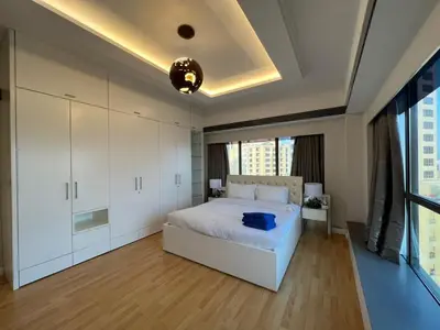 a bedroom with a white bed and white cabinets at Luxurious JBR Beach Facing 4BHK in Dubai