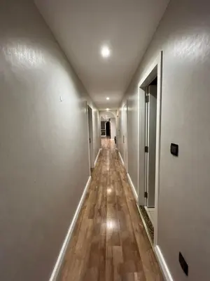 a long hallway with white walls and wooden floors at Luxurious JBR Beach Facing 4BHK in Dubai