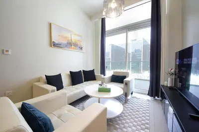 a living room with a white couch and a tv at Wecation Damac Vera - Business Bay in Dubai