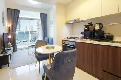 a kitchen with a table and chairs and a counter top at Wecation Damac Vera - Business Bay in Dubai