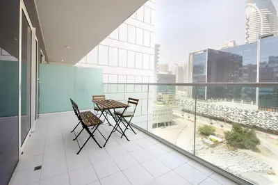 a balcony with a table and chairs on a building at Wecation Damac Vera - Business Bay in Dubai