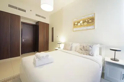 a bedroom with a bed with two towels on it at Wecation Damac Vera - Business Bay in Dubai