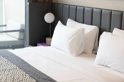 a bed with white sheets and pillows on it at MajeStay - MAG Living in Dubai