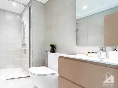 a bathroom with a toilet and a shower and a sink at Luxury One Bedroom with Balcony & partial Burj Khalifa View in Dubai