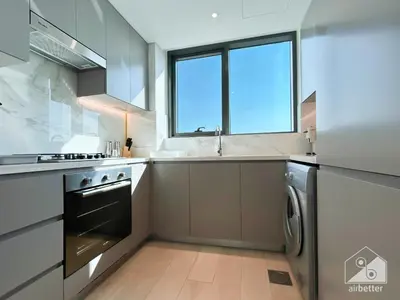 a large kitchen with a sink and a dishwasher at Luxury One Bedroom with Balcony & partial Burj Khalifa View in Dubai