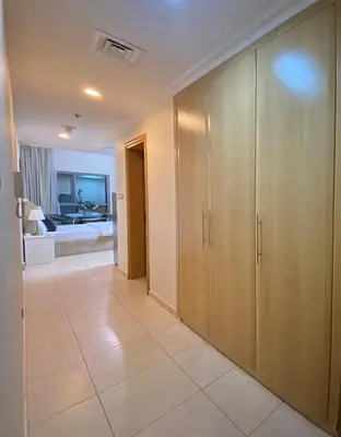 a hallway with wooden cabinets and a living room at Studio near beach and Metro in Dubai Marina Z1003 in Dubai