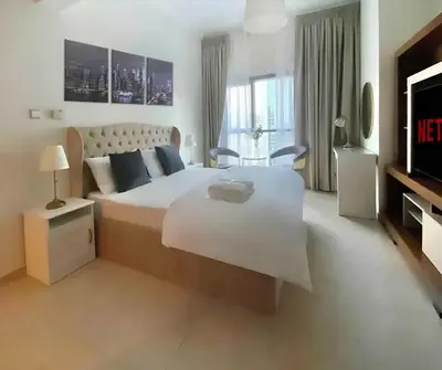 a bedroom with a large white bed and a television at Studio near beach and Metro in Dubai Marina Z1003 in Dubai