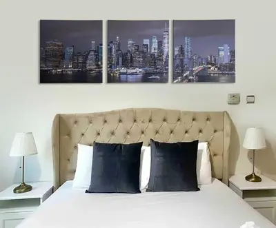 a bedroom with a bed with three paintings on the wall at Studio near beach and Metro in Dubai Marina Z1003 in Dubai