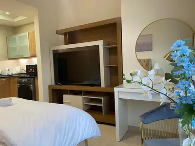 a living room with a television and a white bed at Stylist Studio in Marina near beach and Metro Z1103 in Dubai