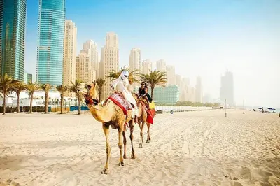 two people riding on camels on a beach with a city at lovely Studio in Dubai Marina near beach Z1009 in Dubai